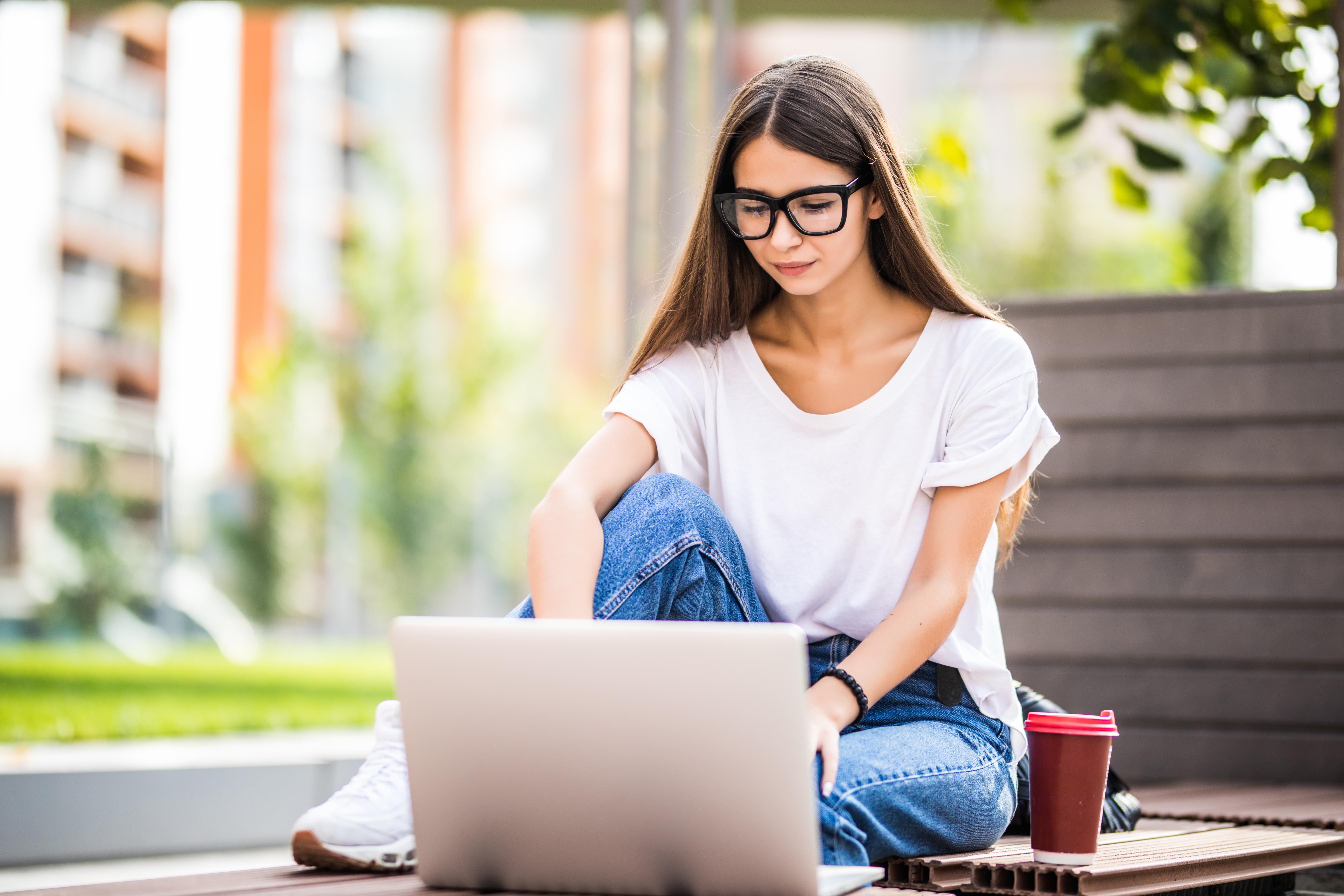 beautiful-young-woman-using-laptop-while-sitting-bench-drinking-takeaway-coffee-cup.jpg